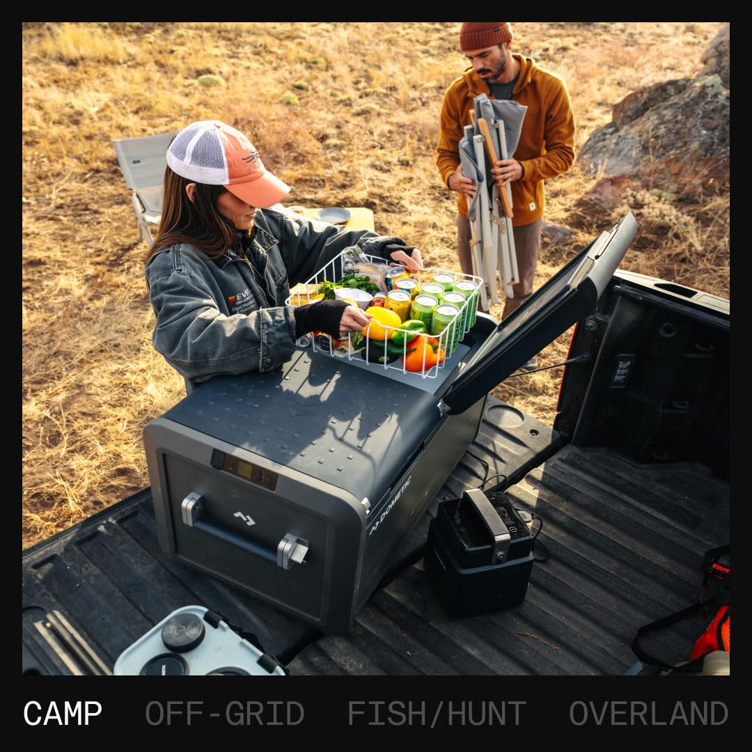 Dometic CFX portable 12V fridge loaded with food and drinks in a truck bed